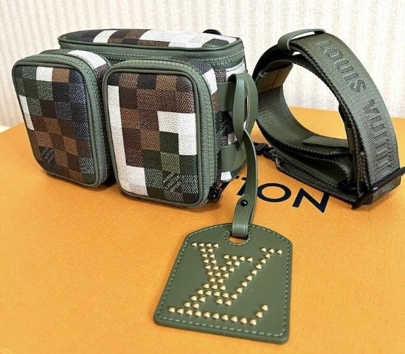 Green checkered bag with matching strap and tag on a Louis Vuitton surface