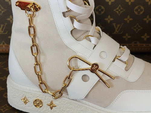 High-top sneakers with gold chain detail on a white background