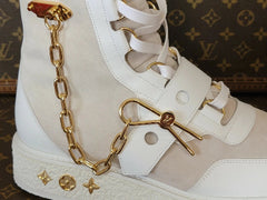 High-top sneakers with gold chain detail on a white background