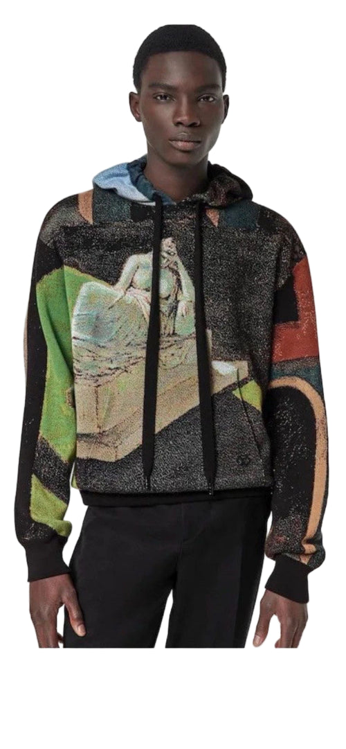 Person wearing a colorful hoodie with abstract patterns on a plain background