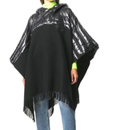 Person wearing a black poncho with reflective hood on a white background