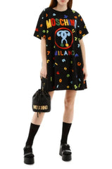 Person wearing a black t-shirt with colorful graphics and text, paired with shorts and black shoes.