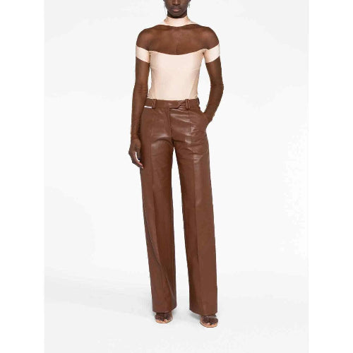 Person wearing a brown leather outfit with a white top on a white background