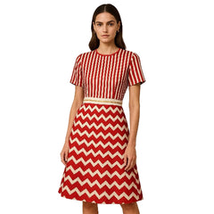 Woman wearing a red and white striped top and chevron pattern skirt on a beige background