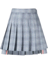 A pleated plaid mini skirt in gray, white, and light blue, featuring a signature red, white, and blue stripe detail along the hem.