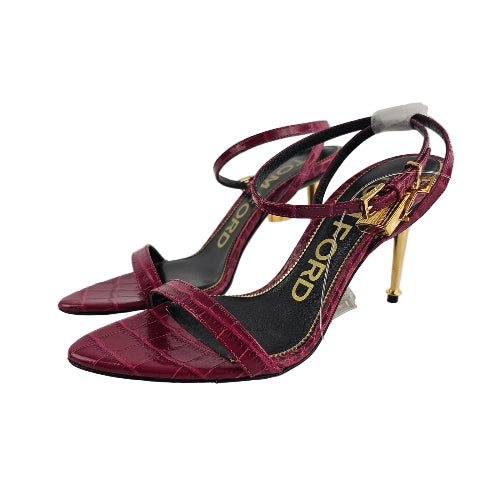 Red high-heeled shoes with gold accents on a white background
