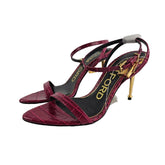 Red high-heeled shoes with gold accents on a white background