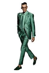 Man wearing a green suit and sunglasses on a black background