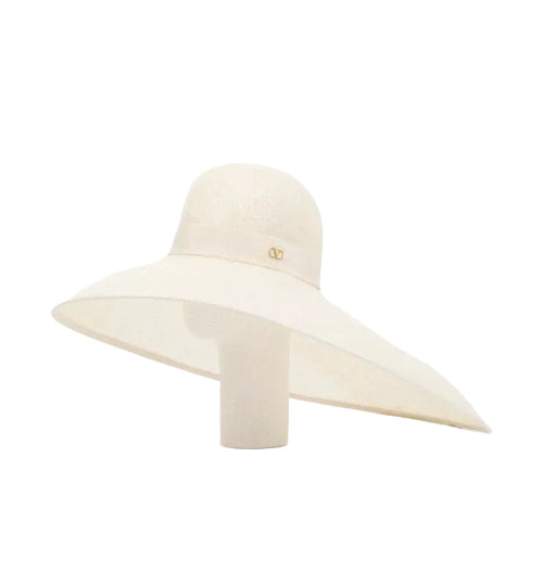 An off-white wide-brimmed sun hat with a small gold interlocking CC logo on the front, displayed on a matching cream-colored mannequin stand against a white background.