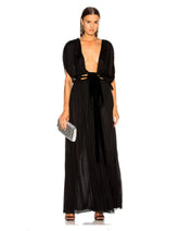 Woman wearing a black evening gown with cut-out design on a white background