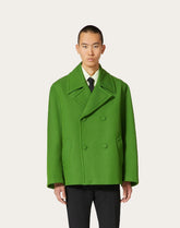 Man wearing a bright green coat on a white background
