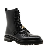 Black rain boot with gold buckle on a white background