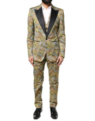 A model wearing a Dolce & Gabbana multicolor camouflage three-piece suit, with a white shirt and black shoes.