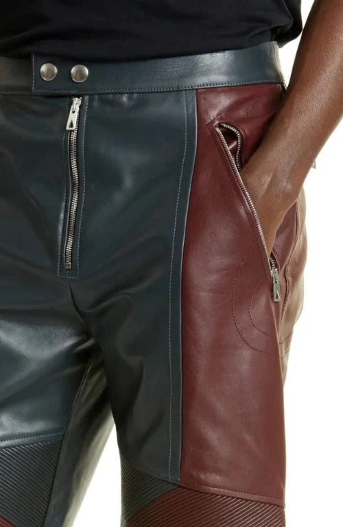 Close-up of a person wearing a black and brown leather outfit with zippers.