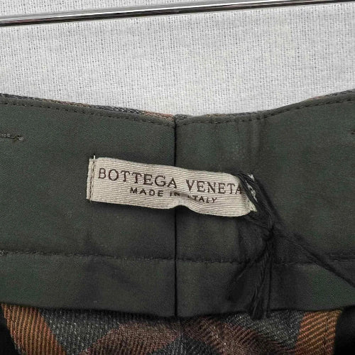 Bottega Veneta label on a green fabric background