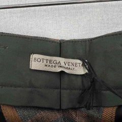 Bottega Veneta label on a green fabric background