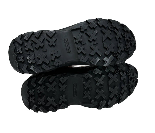 Close-up of black hiking boots with tread pattern on a white background