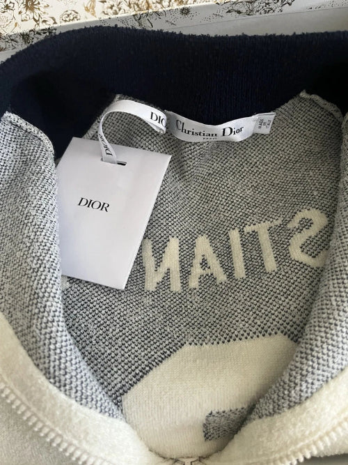 Gray sweater with 'STUSSY' branding and a Dior tag inside a box.