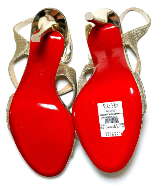 Red high-heeled shoes with gold straps on a white background