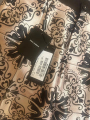 Black leather belt with a decorative pattern on a textured fabric background