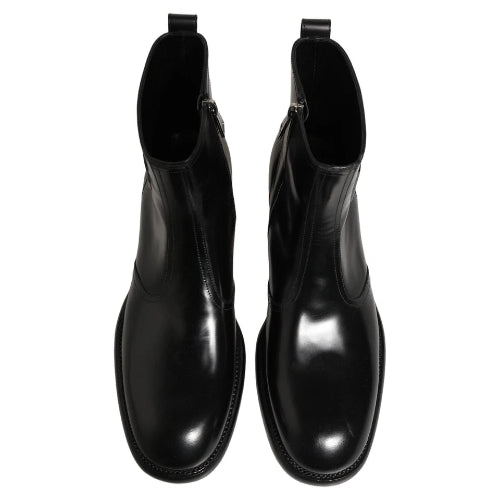 A pair of black leather Chelsea boots with elastic side panels and round toes, shown from a front-facing perspective on a white background.