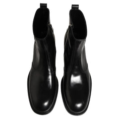 A pair of black leather Chelsea boots with elastic side panels and round toes, shown from a front-facing perspective on a white background.