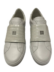 Pair of light gray sneakers with a brand logo on a light gray background