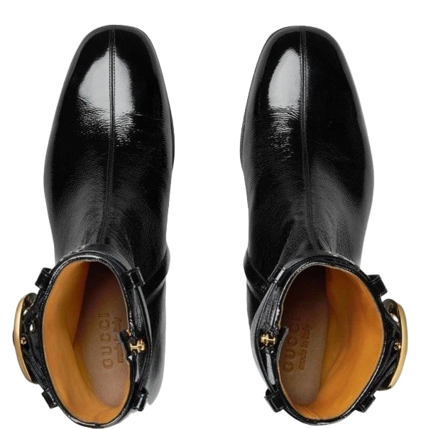 Black leather boots with gold accents on a light gray background