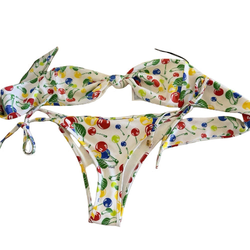 Colorful bikini set with cherry pattern on a beige surface