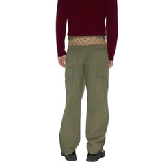 Person wearing green cargo pants with a red sweater and patterned underwear on a white background