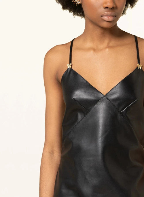Black leather dress worn by a model on a white background