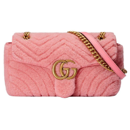 Pink quilted handbag with gold chain strap and logo on a light gray background