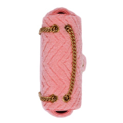 Pink knitted clutch with a gold chain on a white background