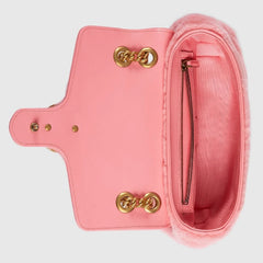 Pink handbag with gold hardware on a light gray background