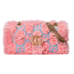 Pink floral handbag with gold and blue accents on a light gray background