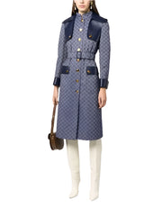 Person wearing a patterned coat with navy accents on a white background