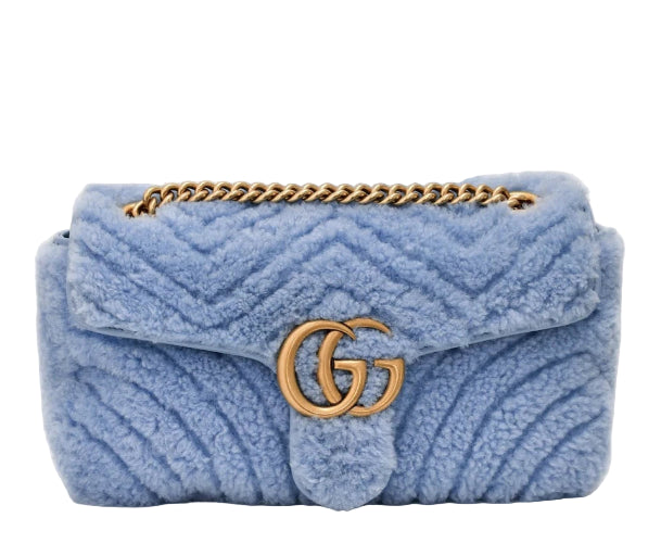 Blue textured handbag with gold chain and logo on a white background