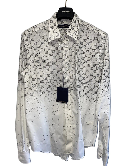 White shirt with black pattern on a hanger against a white door background