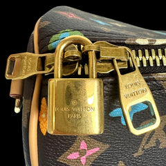 Gold Louis Vuitton padlock on a patterned bag