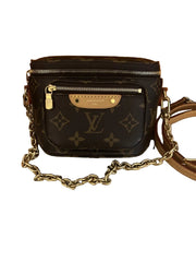 Designer handbag with gold chain strap on a white background