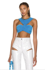 Woman wearing a blue top and white pants on a white background