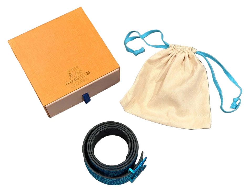 Orange box, black belt, beige drawstring bag on a gray tiled floor