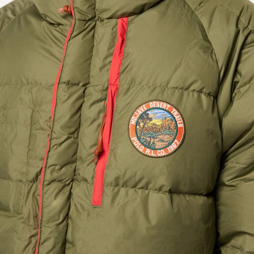 Green puffer jacket with a colorful patch on the chest