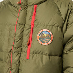 Green puffer jacket with a colorful patch on the chest