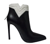Black high-heeled boot with white quilted design on a gray background
