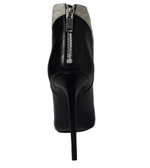 Black high-heeled shoe with a zipper on a gray background