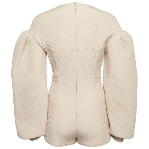 A cream-colored quilted jacket with dramatic puffed sleeves, shown from the back against a light gray background.
