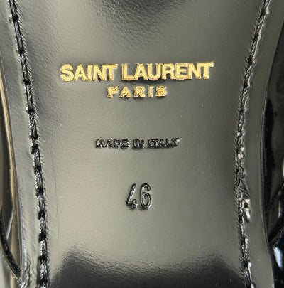 Close-up of a black leather shoe insole with gold Saint Laurent Paris branding, 'Made in Italy' text, and size '46' stamped on a glossy surface.