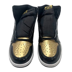 Black and gold sneakers with Nike Air logo on a light gray background