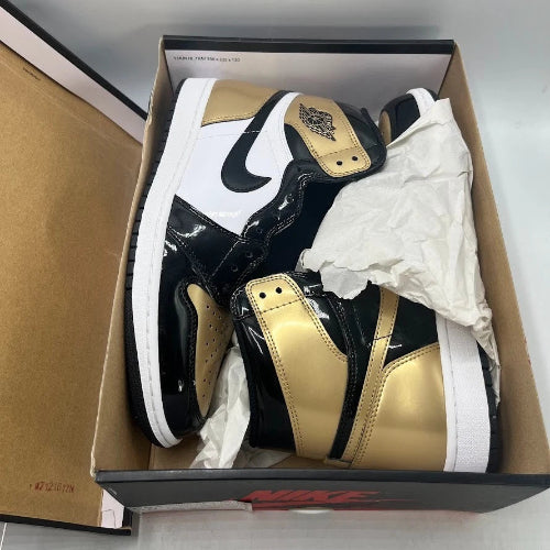 Black and gold sneakers in a Nike box with tissue paper.